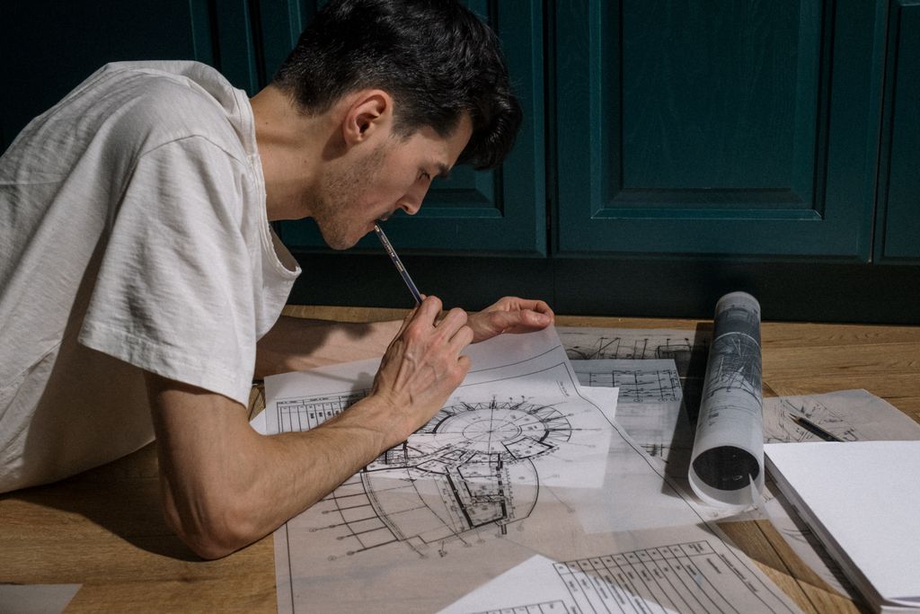Focused architect drawing floor plans indoors on a tablet for a design project.